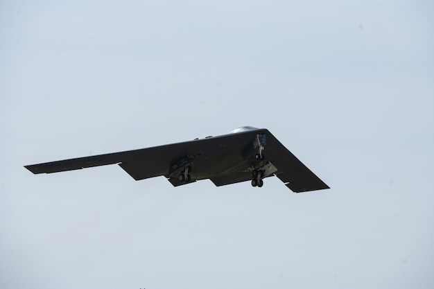 A black b - 52 bomber is flying in the sky.