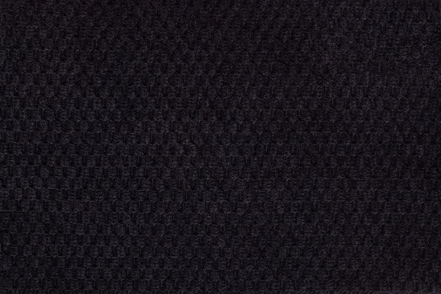 Black background from soft fleecy fabric closeup. Texture of textiles macro