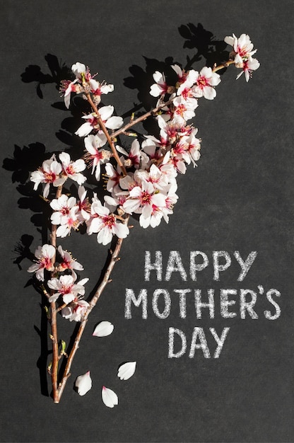 a black background with of a branch of cherry blossoms the words happy mother's day written on it