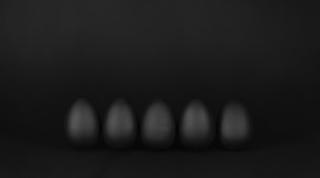 A black background with a series of eggs in the middle of the image.