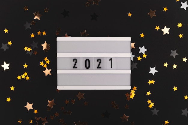 Black background with stars that shine and  written panel Happy new year background copy space