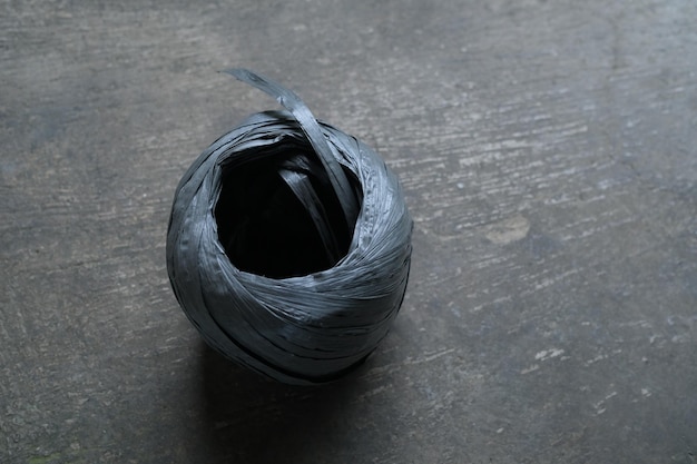 A black bag of charcoal sits on a wooden floor.