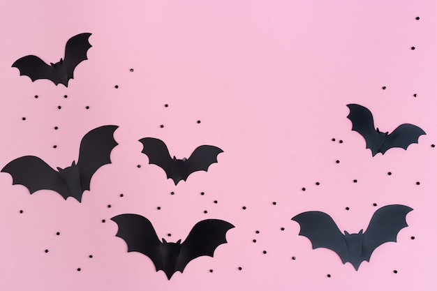 Black bats on a pink background