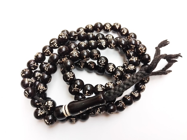 Photo a black beaded tasbih is on a white surface