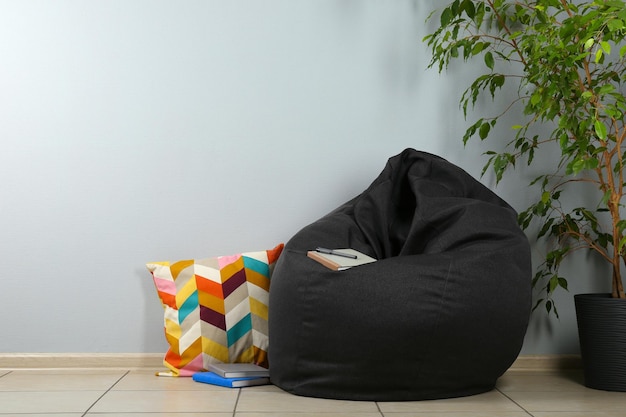 Black bean bag chair near light grey wall in room Space for text