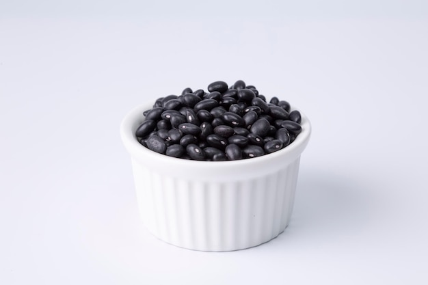 Black bean in white bowl on white background studio shot