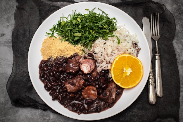 Black beans stew with sausages on a white dish