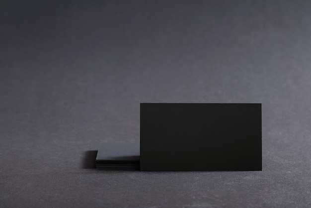 Black blank business cards on a black surface.