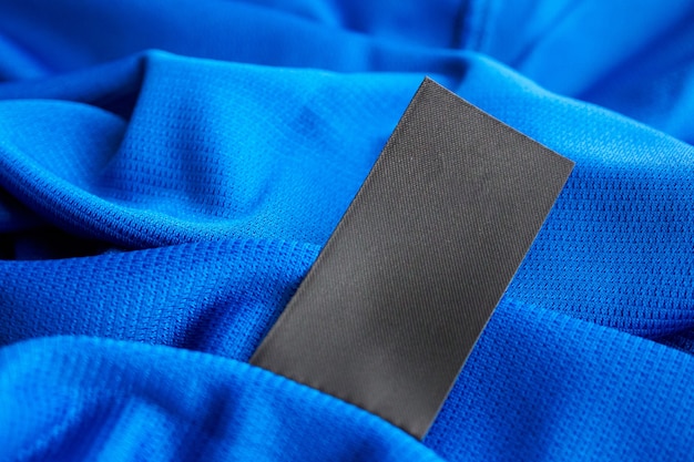 Черная пустая этикетка для стирки одежды на синем джерси