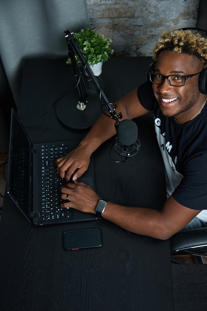 Black blogger with professional microphone records program for radio broadcast