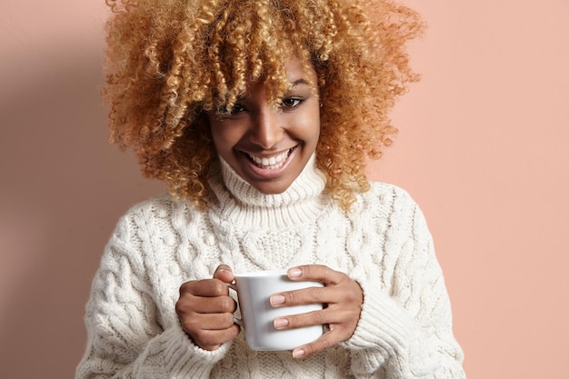 Photo black blond woman with a cup of tea or coffee knittedwear