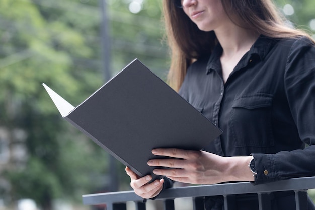 Photo black book cover in woman39s hands book cover for mock up