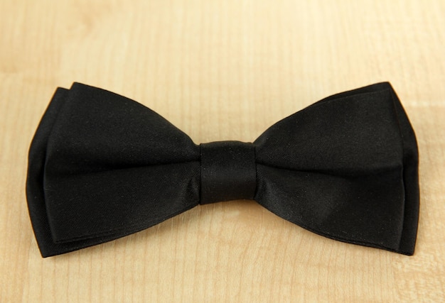 Black bow tie on wooden background