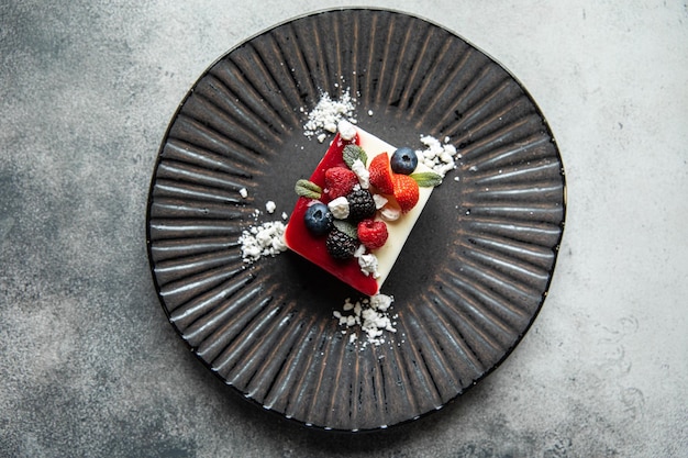 Black bowl and cheesecake cake strawberry cheesecake in black\
ceramic dish