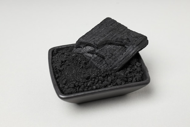 Black bowl with charcoal and powdered charcoal