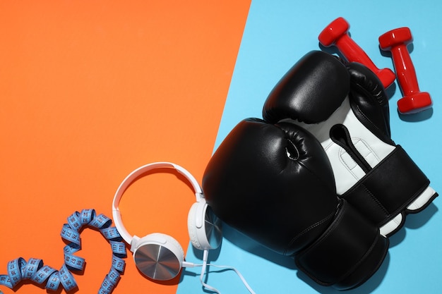 Photo black boxing gloves with dumbbells and headphones