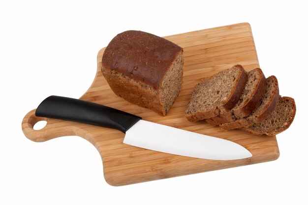 Black bread and knife on kitchen board on white background