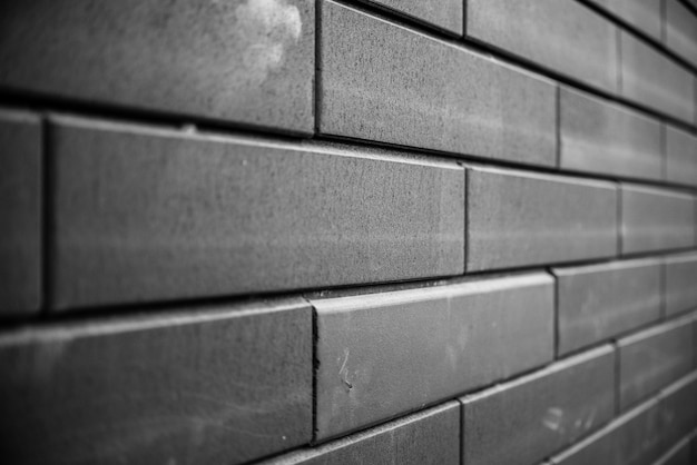 黒レンガの壁。アーバンブラックレンガ壁テクスチャ石積みの背景。