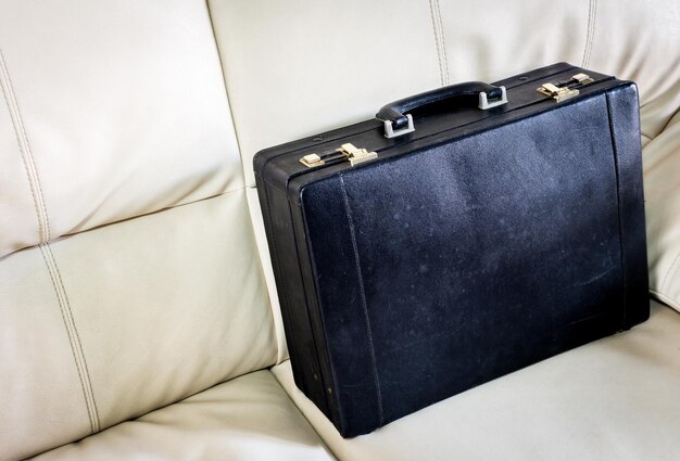Black briefcase on white sofa