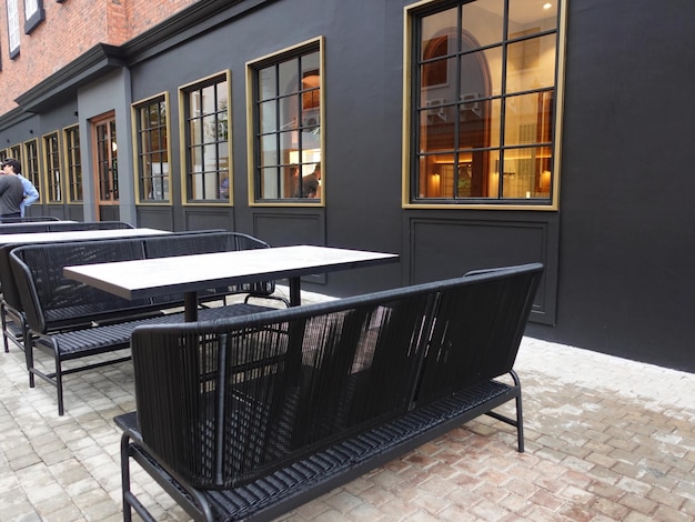 A black building with a black wall and a table with chairs and a sign that says'the word '