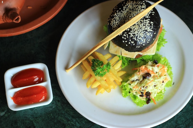 Black Burger with fried fries background