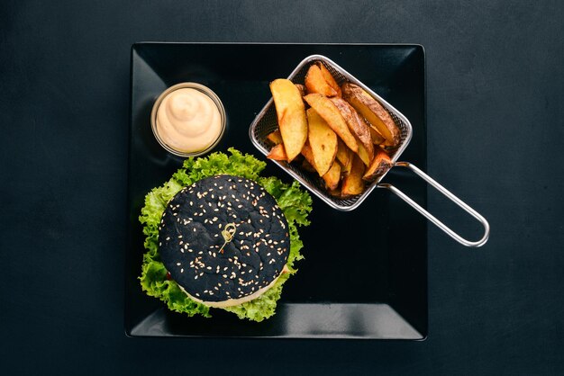 Black burger with meat onion and lettuce On a wooden background Top view Copy space