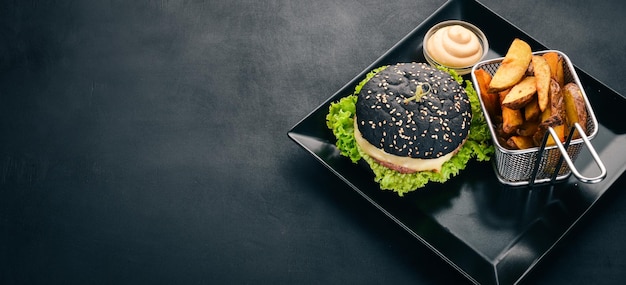 Black burger with meat onion and lettuce On a wooden background Top view Copy space