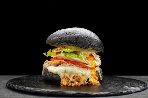 Black burger with turkey cheese sauce lettuce and tomatoes