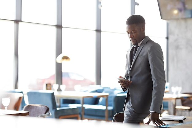 Black businessman checking sms on phone