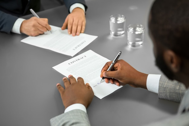 Black businessman signs a contract. Welcome to the company. Chief employs manager. A successful candidate.