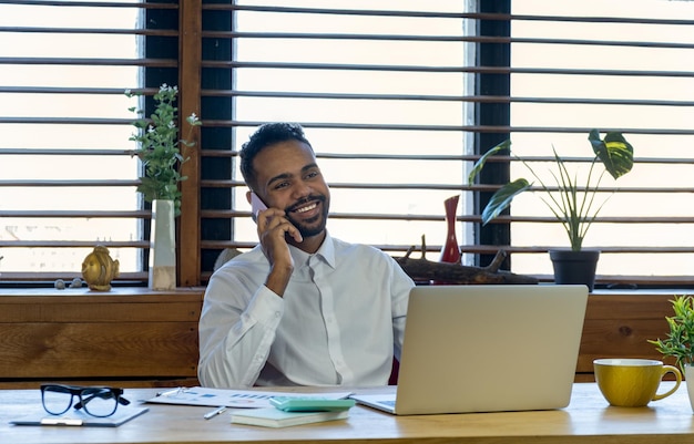 Black businessman talking on cell phone at office