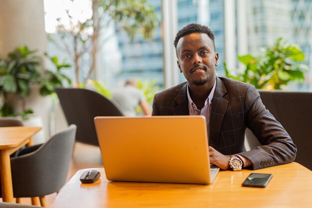 Black businessman using laptop computer at coffee shop