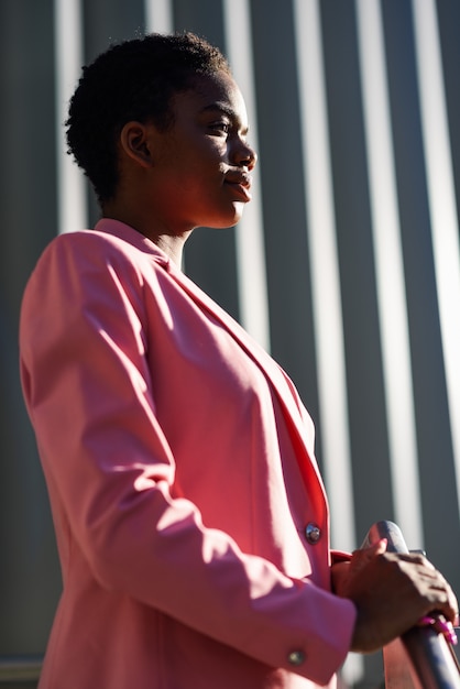 Foto donna di affari nera che sta l'edificio per uffici vicino di affari