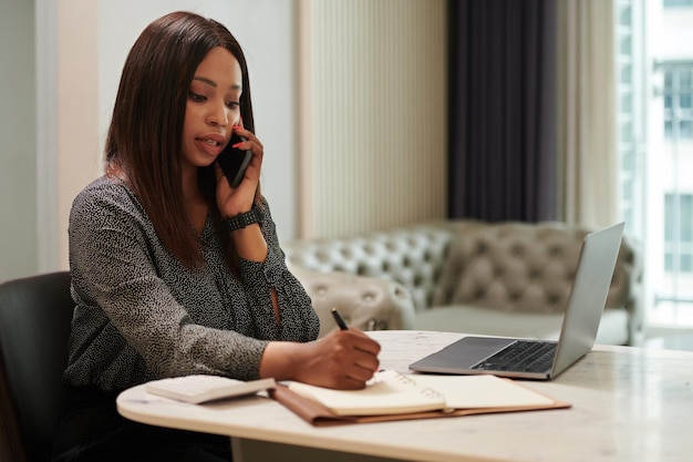 Black Businesswoman Writing in Planner