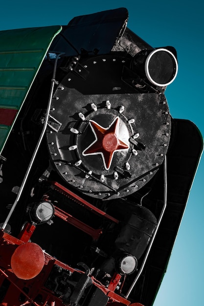 Black cabin of old soviet steam locomotive with red star close up dramatic and contrast