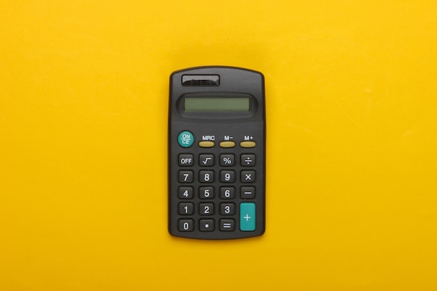 Black calculator on yellow.