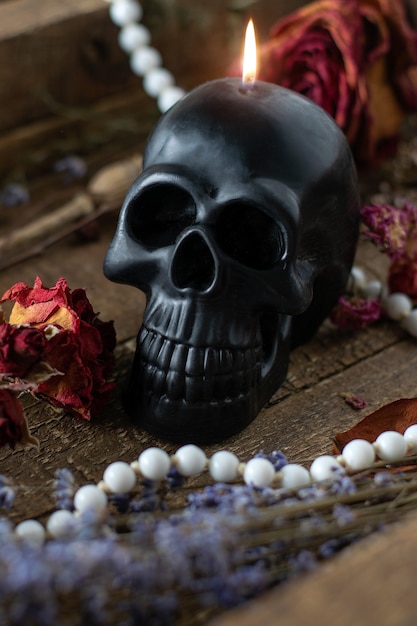 Black candle scull on witch table. Occult, esoteric, divination and wicca concept. Halloween concepte