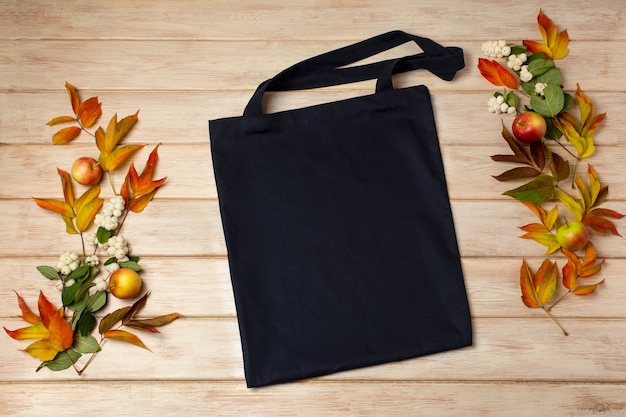 Foto mockup di borsa tote in tela nera con foglie autunnali e ghostberry borsa shopper in lino rustico mock up