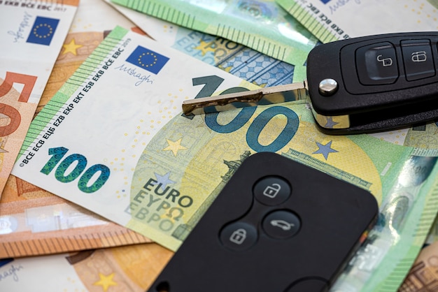 Black car key on euro money, insurance or rent car. Sales concept