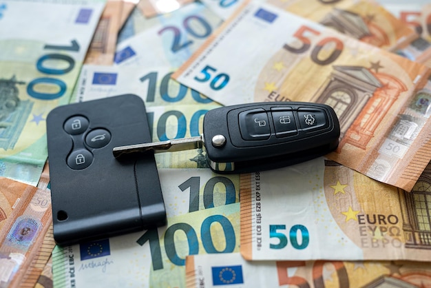 La chiave dell'auto nera si trova su soldi in euro come sfondo, assicurazione auto. vendita pr affitto