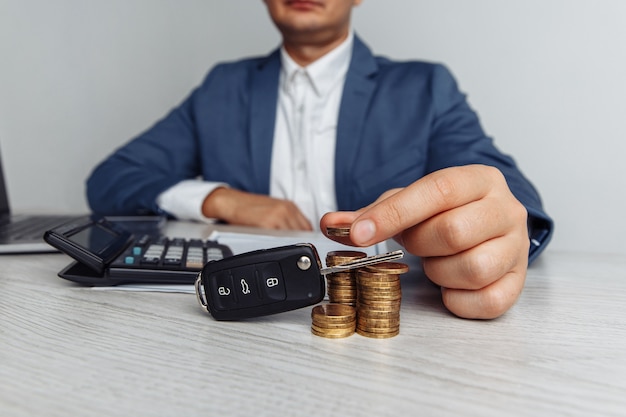 Black car key with contract on wooden table and man with money. Concept business finance and insurance, savings plans for car