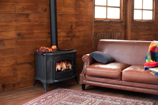 black cast iron fire place with wood burning. Fragment of the interior of a country house