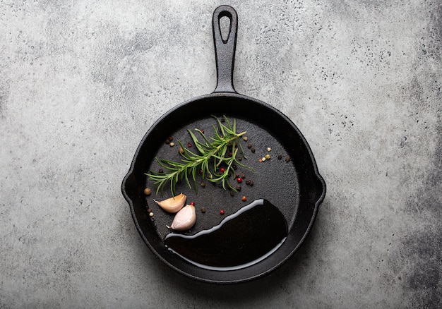 Black cast iron frying pan with rosemary garlic pepper oil