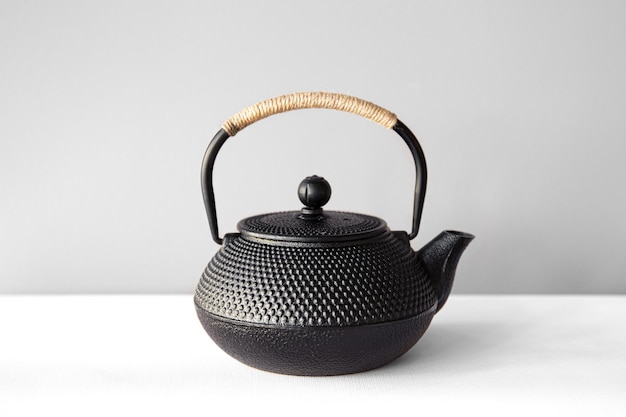 Black cast iron teapot on a white background