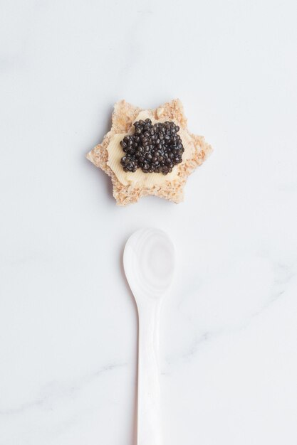 Black caviar appetizers bread star on a white background top view