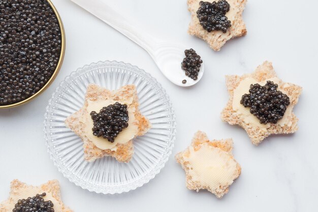 Black caviar appetizers bread star on a white background top view