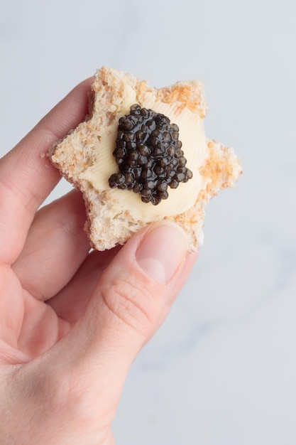 Black caviar appetizers bread star on a white background top view