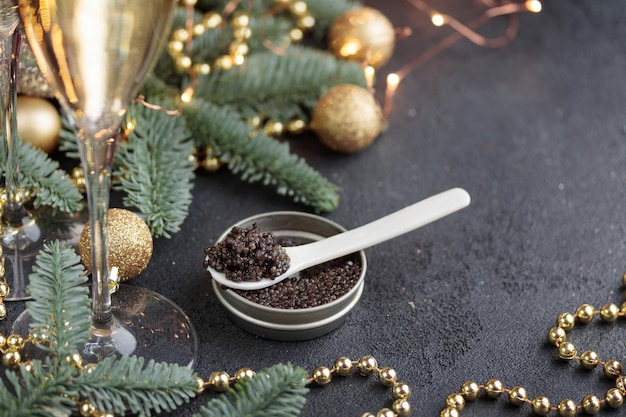 Black caviar in a motherofpearl spoon with Christmas decoration