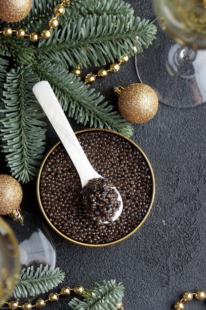 Black caviar in a motherofpearl spoon with Christmas decoration