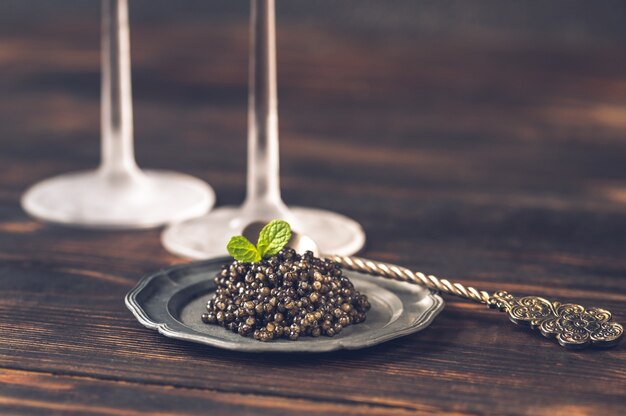 Black caviar on silver vintage plate close-up